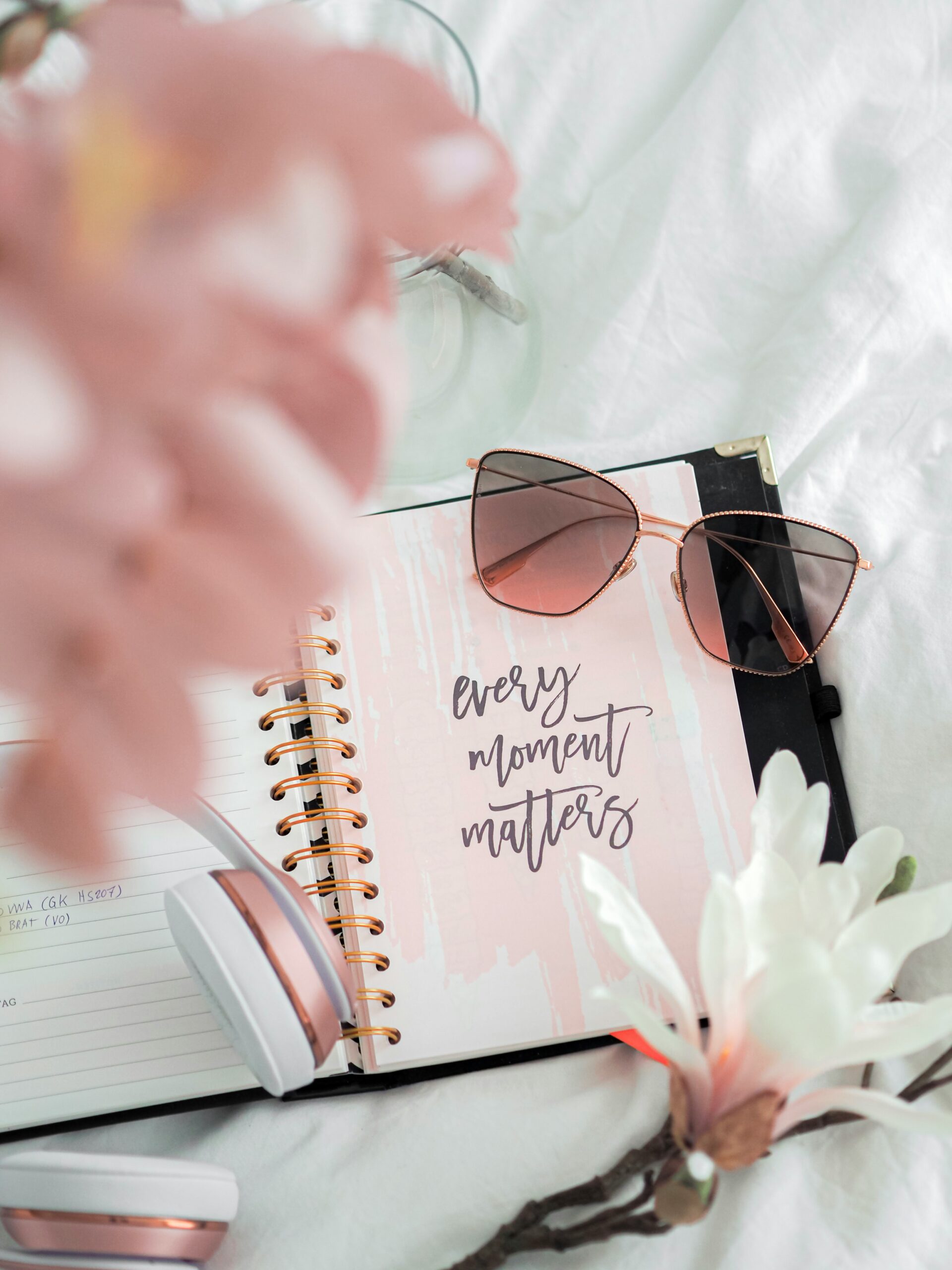 An open notebook with uplifting handwritten words surrounded by soft flowers and gentle light.<br />
